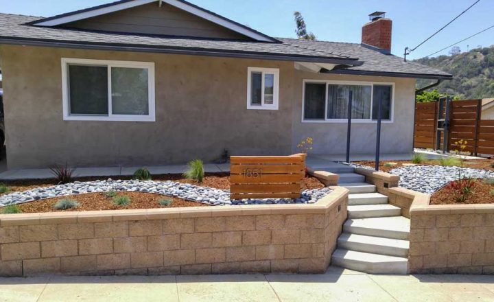 front view of a new house construction with a unique landscape, concrete steps and retaining walls